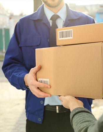 A delivery courier handing over cardboard boxes